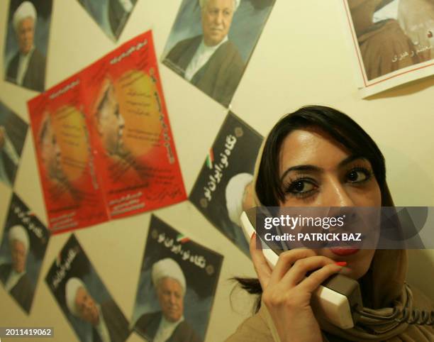 An Iranian supporter of presidential candidate, pragmatic cleric Akbar Hashemi Rafsanjani, answers the phone in one of his election campaign office...