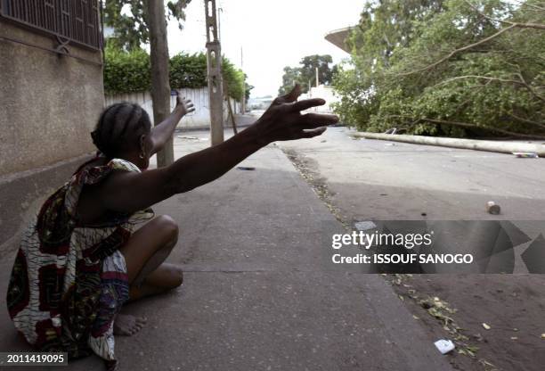 Woman calls for help outside her home in a district of Lome, 26 April 2005 following violent clashes with police forces that erupted after the...