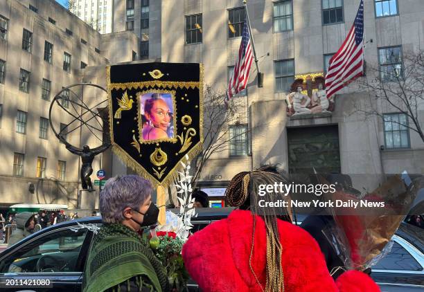 People with flowers and a banner honoring Cecilia Gentili outside St. Patrick's Cathedral in Manhattan on Feb. 15 in New York.