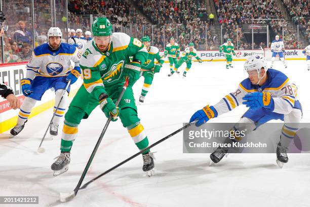 Jacob Bryson and Alex Tuch of the Buffalo Sabres defend Frederick Gaudreau of the Minnesota Wild during the game at the Xcel Energy Center on...