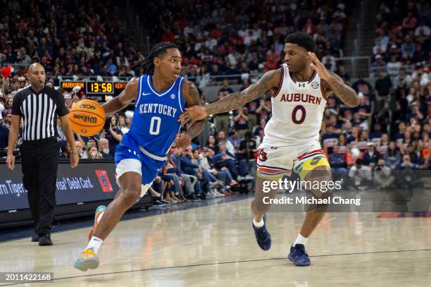 Rob Dillingham of the Kentucky Wildcats looks to maneuver the ball by K.D. Johnson of the Auburn Tigers during the first half of play at Neville...