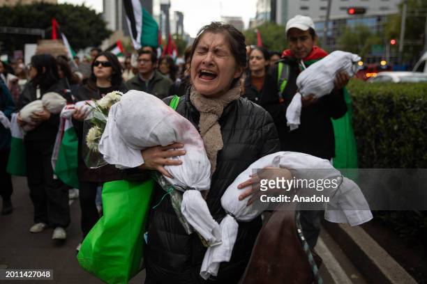 Protestor holds a simulated bodies of a children during the Global March for Rafah to demand an immediate ceasefire in Gaza, in Mexico City, Mexico...