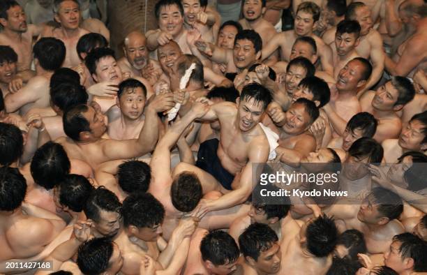 Men wearing only loincloths jostle in a bid to catch a sacred wood stick at the over-500-year-old Saidaiji Eyo festival at the Saidaiji temple in the...
