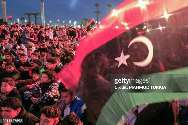 Libyans gather at Martyrs' Square in Tripoli late on February 17, 2024 to mark the 13th anniversary of the uprising that toppled longtime strongman...