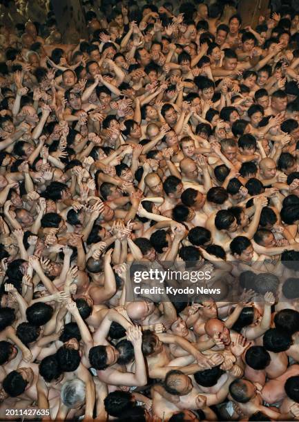 Men wearing only loincloths jostle in a bid to catch a sacred wood stick at the over-500-year-old Saidaiji Eyo festival at the Saidaiji temple in the...