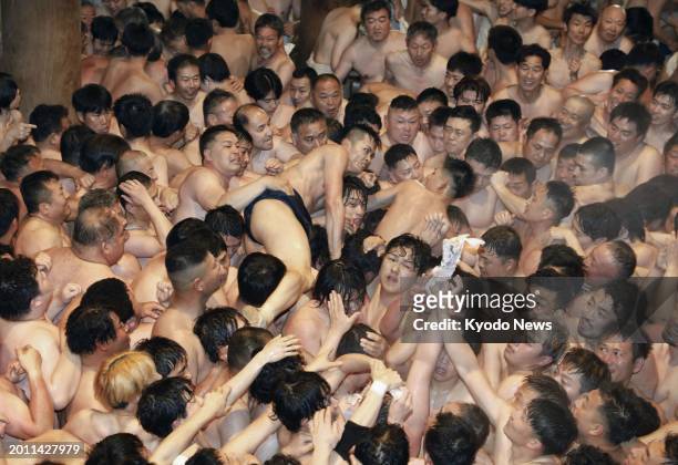 Men wearing only loincloths jostle in a bid to catch a sacred wood stick at the over-500-year-old Saidaiji Eyo festival at the Saidaiji temple in the...