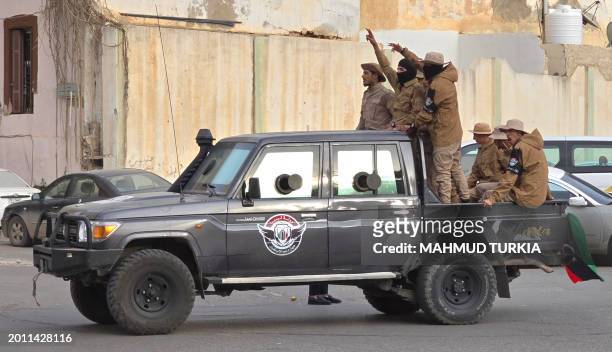 Libyan security forces parade in the streets of Tripoli during celebrations on February 17 marking the 13th anniversary of the uprising that toppled...