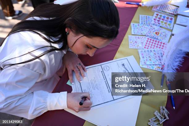 Laura Vergel signs her marriage certificate after getting married on the steps of the City and County building during the 16th Annual Burning Love...
