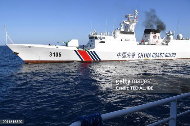 This photo taken on February 15, 2024 shows a Chinese coast guard ship shadowing the Philippine Bureau of Fisheries and Aquatic Resources ship BRP...