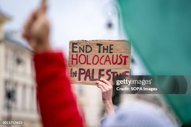 Woman holds a banner that says: "End the holocaust in Palestine" at the Solidarity with Palestine rally in Warsaw. Hundreds of Pro-Palestinian...