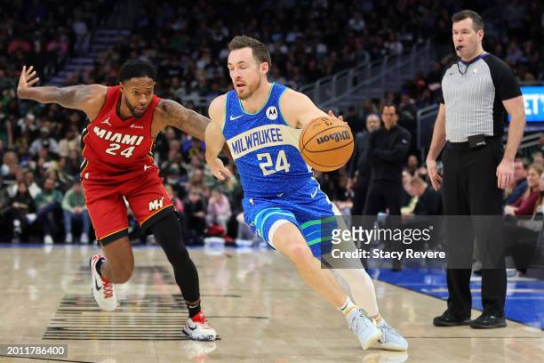 Pat Connaughton of the Milwaukee Bucks drives around Haywood Highsmith of the Miami Heat during a game at Fiserv Forum on February 13, 2024 in...