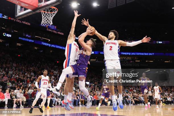 Grayson Allen of the Phoenix Suns attempts a shot against Simone Fontecchio and Cade Cunningham of the Detroit Pistons during the first half of the...