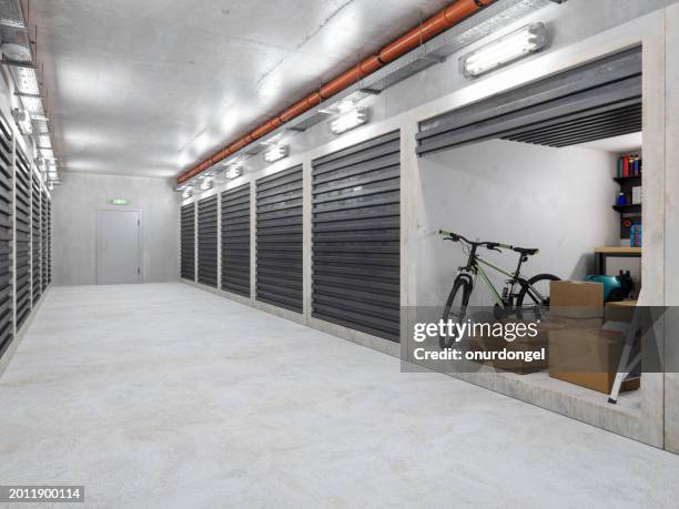 edificio de almacén de autoalmacenamiento. pasillo vacío con trasteros. cajas de cartón, bicicletas y otros equipos en unidad abierta - self storage fotografías e imágenes de stock