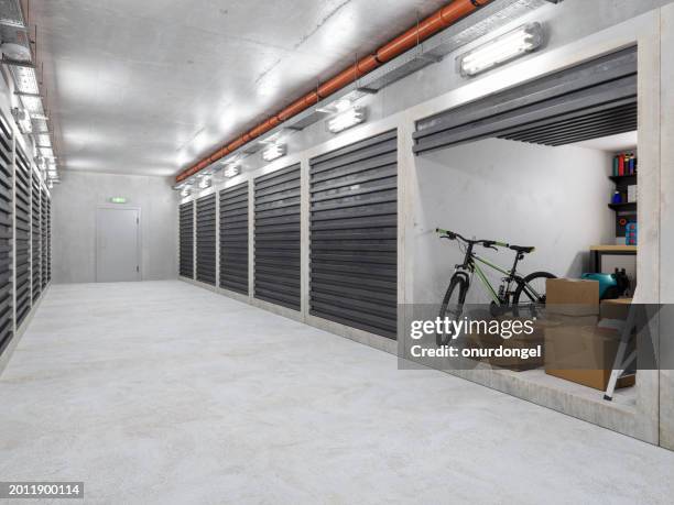 edificio del magazzino di self storage. corridoio vuoto con unità di self storage. scatole di cartone, biciclette e altre attrezzature in unità aperta - scompartimento di immagazzinaggio foto e immagini stock