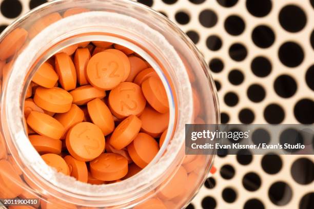 ibuprofen tablets in a plastic container on a futuristic background - ibuprofen stock pictures, royalty-free photos & images