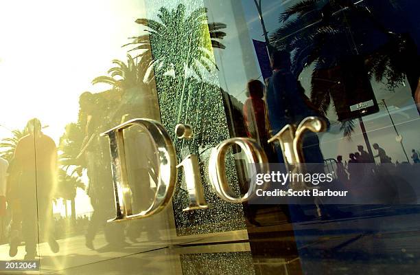 Pedestrians are reflected in the window of a Dior shop as they walk past during the 56th International Cannes Film Festival 2003 May 19, 2003 in...