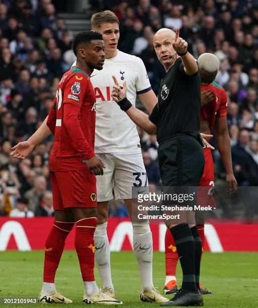 Referee Anthony Taylor in conversation with Wolverhampton Wanderers' Joao Gomes during the Premier League match between Tottenham Hotspur and...