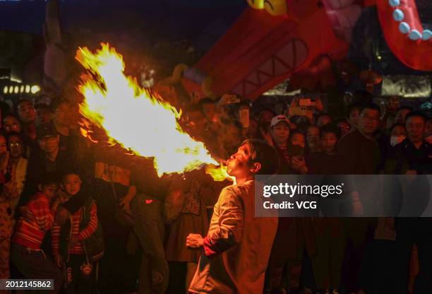 Tourists watch fire spitting performance at 'Nanning Night' block during the Spring Festival holiday on February 14, 2024 in Nanning, Guangxi Zhuang...