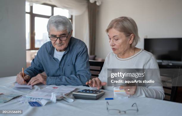 couple de personnes âgées calculant ensemble le budget - pension de retraite photos et images de collection