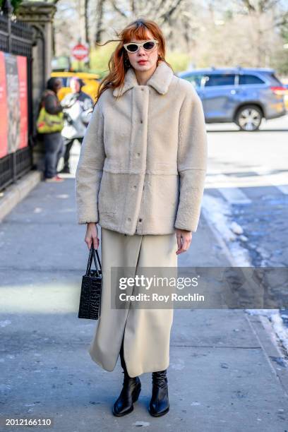 Brianna Lance is seen wearing a cream faux fur jacket, cream skirt, black bag and black boots outside the Bevza Fashion Show at The Ukrainian...
