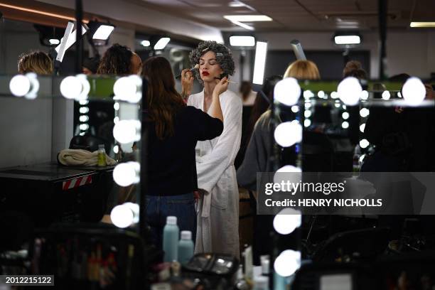 Model is prepared back-stage ahead of the catwalk presentation for British fashion label JW Anderson for their Autumn/Winter 2024 collection during...