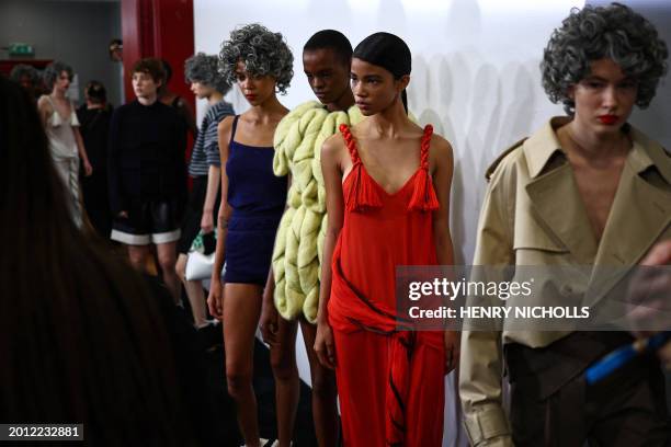 Models pose for photographs back-stage ahead of the catwalk presentation for British fashion label JW Anderson for their Autumn/Winter 2024...