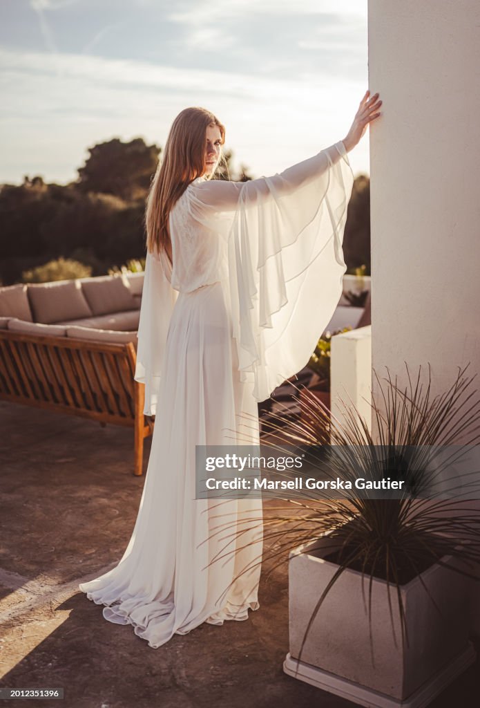 A woman in a wedding dress poses on a cliff. ( Boho style)praca