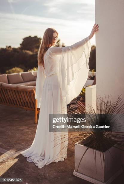 a woman in a wedding dress poses on a cliff. ( boho style)praca - cream coloured dress stock pictures, royalty-free photos & images