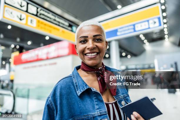 portrait of a mature woman at airport - passport holder stock pictures, royalty-free photos & images