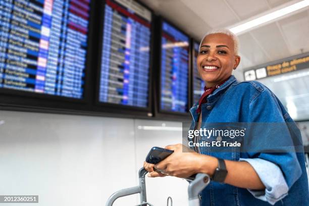 portrait of a mature woman at airport - woman flying scarf stock pictures, royalty-free photos & images