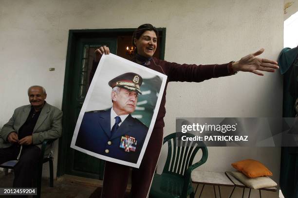 Lebanese Eliane Hachahe gestures as she shows a poster of Lebanese army commander and presidential candidate Michel Sleiman in his home town of...