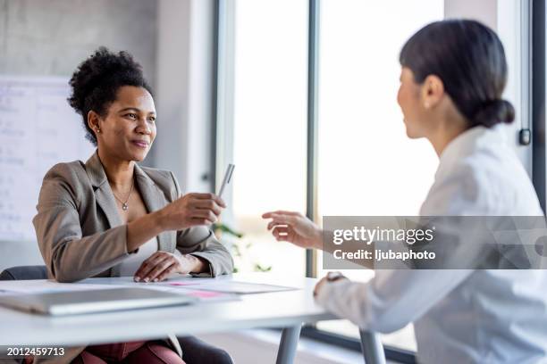 lawyer is explaining the terms of the legal contract document and asking the client to sign it properly. - notary stock pictures, royalty-free photos & images