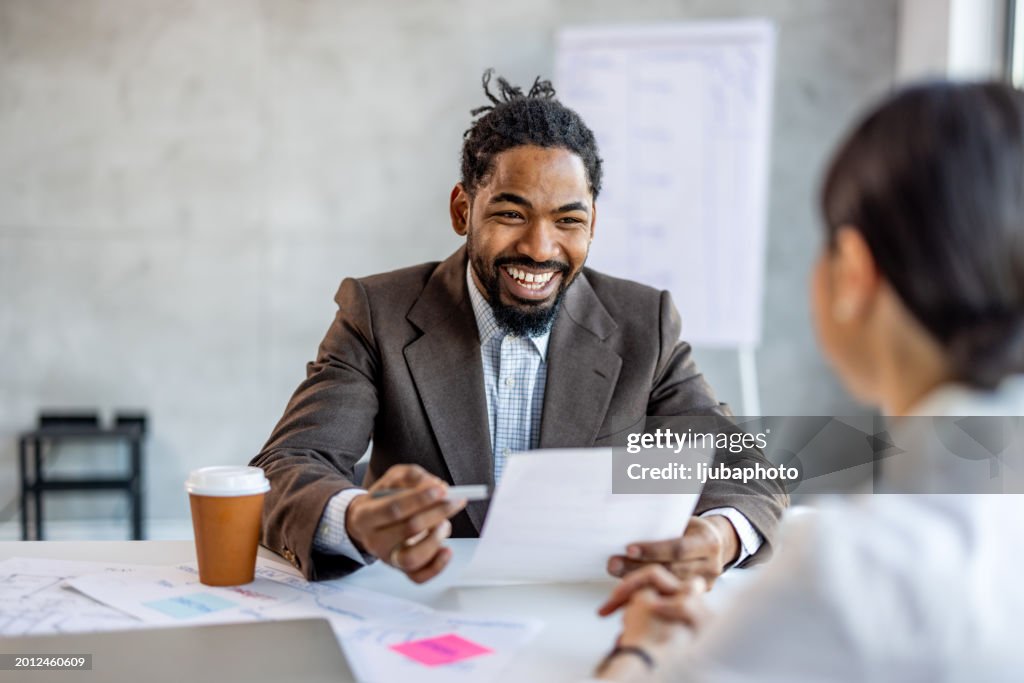 Happy businessman interviewing a job candidate in his office
