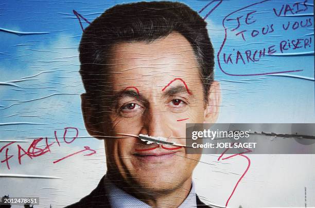 Picture taken 27 April 2007 in Paris, shows a close-up of the campaign poster of of French right-wing UMP presidential candidate Nicolas Sarkoz, with...