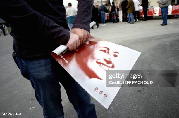 Supporter of French socialist candidate Segolene Royal rolls a campaign poster, 12 April 2007 in Besancon, prior to a Segolene Royal's meeting . AFP...