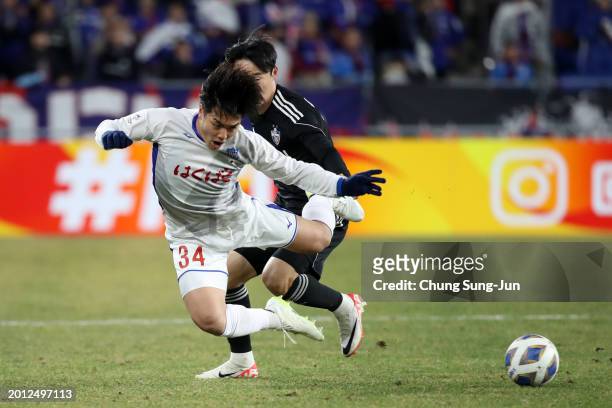 Takuto Kimura of Ventforet Kofu is challenged by Um Won-sang of Ulsan Hyundai during the AFC Champions League Round of 16 first leg match between...