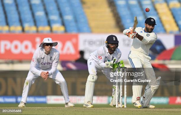 India batsman Ravindra Jadeja hits out watched by Ben Foakes during day one of the 3rd Test Match between India and England at Saurashtra Cricket...