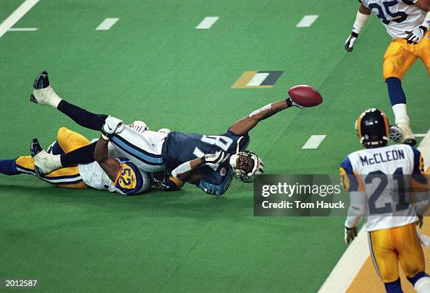 Kevin Dyson of the Tennessee Titans reaches for the end zone with the ball as Mike Jones of the St. Louis Rams tackles him on the last play of the...