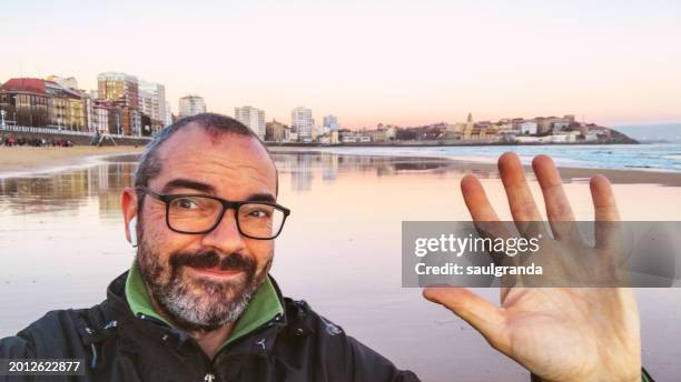 adult man with glasses taking a selfie on the beach - parte del cuerpo humano stock pictures, royalty-free photos & images