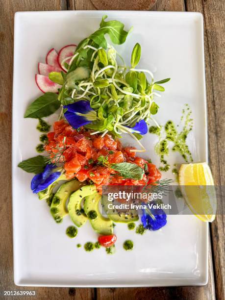 healthy food concept. salmon and avocado salad in the plate on outdoor restaurant on tropical island. - stoffwechsel entgiftung stock-fotos und bilder