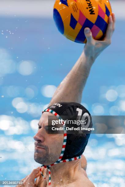 Denes Varga of Hungary controls the ball competes in the Men's Water Polo match between Serbia and Hungary on day fourteen of the Doha 2024 World...