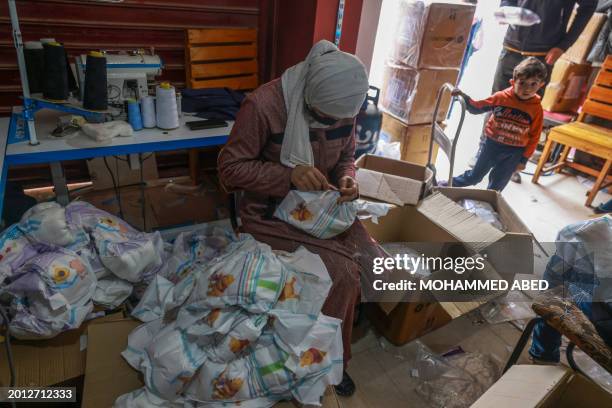 Palestinian woman sews diapers at a workshop in Rafah in the southern Gaza Strip, on February 18 amid severe shortages of basic necessities since the...