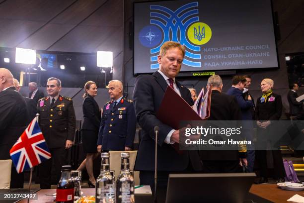 British Secretary of State for Defence Grant Shapps examines documents provided by members of his delegation before the start of the Ukraine Council...