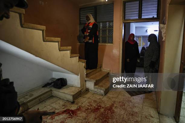 Medics and people walk past blood stains at an apartment where Mohammed al-Oufi was reportedly killed by Israeli soldiers during a raid on the...