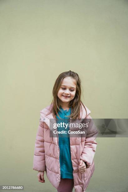 cute seven year old girl posing against pastel wall - coco stock pictures, royalty-free photos & images