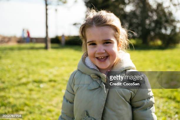 elementary age kids outdoors in park, posing and looking at camera - coco stock pictures, royalty-free photos & images