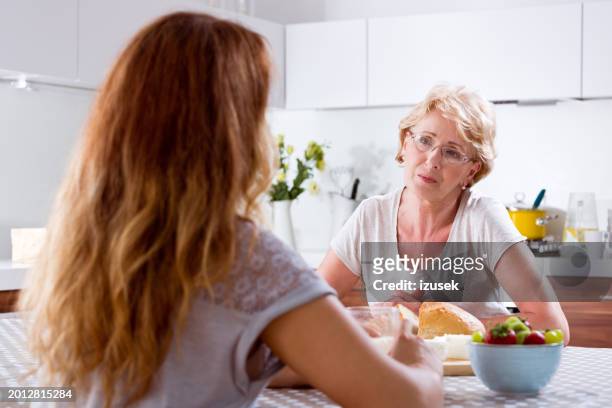 senior woman talking with adult daughter - mama stock pictures, royalty-free photos & images