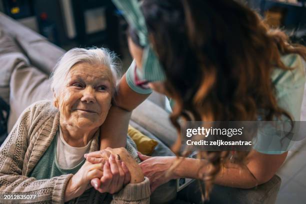 a nurse visits an elderly disabled woman at home and helps her - gezondheidszorg beroep stockfoto's en -beelden