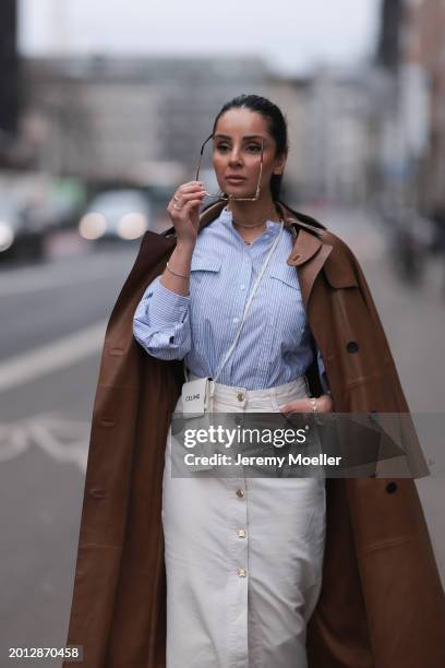 Tara Tut seen wearing Celine gold Triomphe sunglasses, gold earrings, & Other Stories blue / white striped buttoned blouse shirt, Zara white denim /...