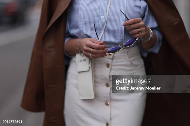 Tara Tut seen wearing Celine gold Triomphe sunglasses, gold earrings, & Other Stories blue / white striped buttoned blouse shirt, Zara white denim /...